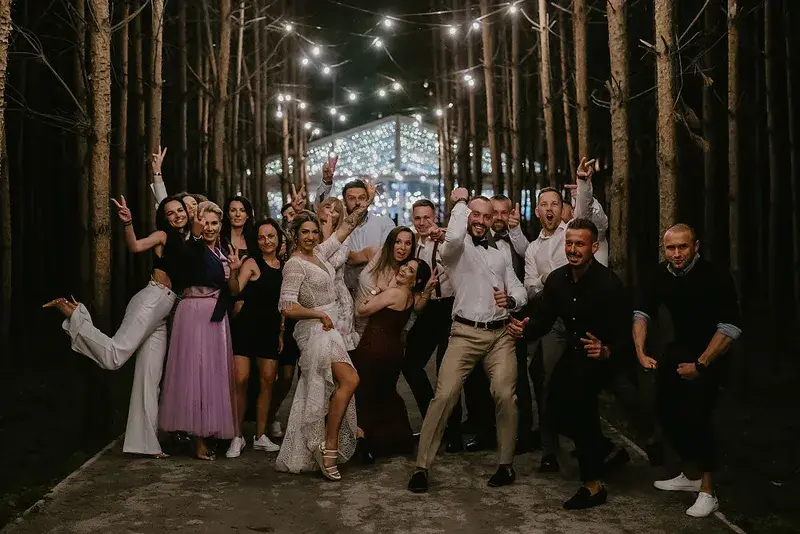 Goście weselni pozują do wspólnego zdjęcia podczas wieczornej zabawy