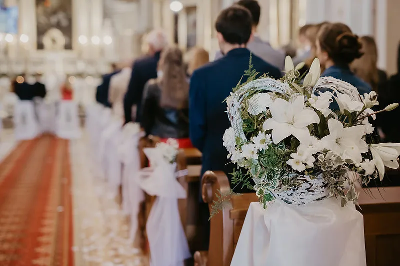Kwiatowe dekoracje ławek w kościele przed ceremonią ślubną Kwiatowe dekoracje ławek w kościele przed ceremonią ślubną