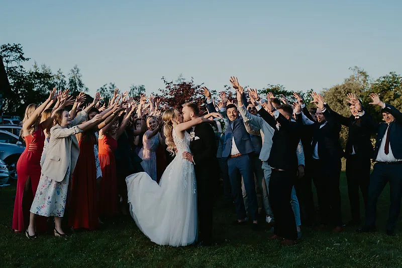 Para młoda i goście podczas wspólnego zdjęcia plenerowego