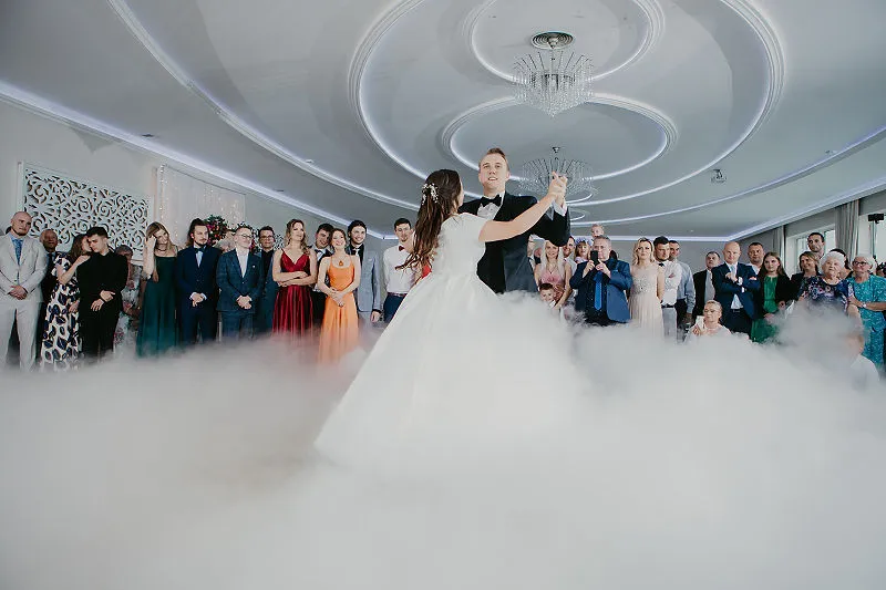 Goście obserwują pierwszy taniec na sali weselnej Goście obserwują pierwszy taniec na sali weselnej