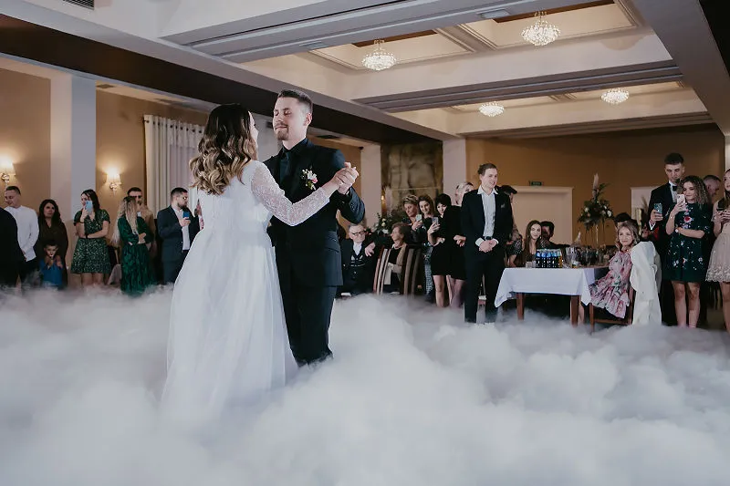 Para Młoda tańcząca pierwszy taniec w sali weselnej otoczonej gośćmi Para Młoda tańcząca pierwszy taniec w sali weselnej otoczonej gośćmi