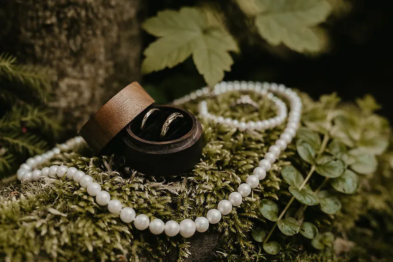 Obrączki i perły ułożone na mchu podczas przygotowań ślubnych Obrączki i perły ułożone na mchu podczas przygotowań ślubnych