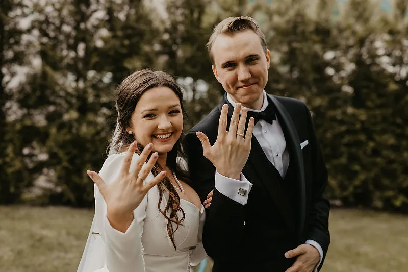 Nowożeńcy pokazują obrączki po ceremonii ślubu cywilnego Nowożeńcy pokazują obrączki po ceremonii ślubu cywilnego