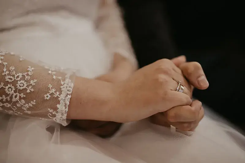Dłonie Panny Młodej z obrączką podczas ceremonii ślubnej