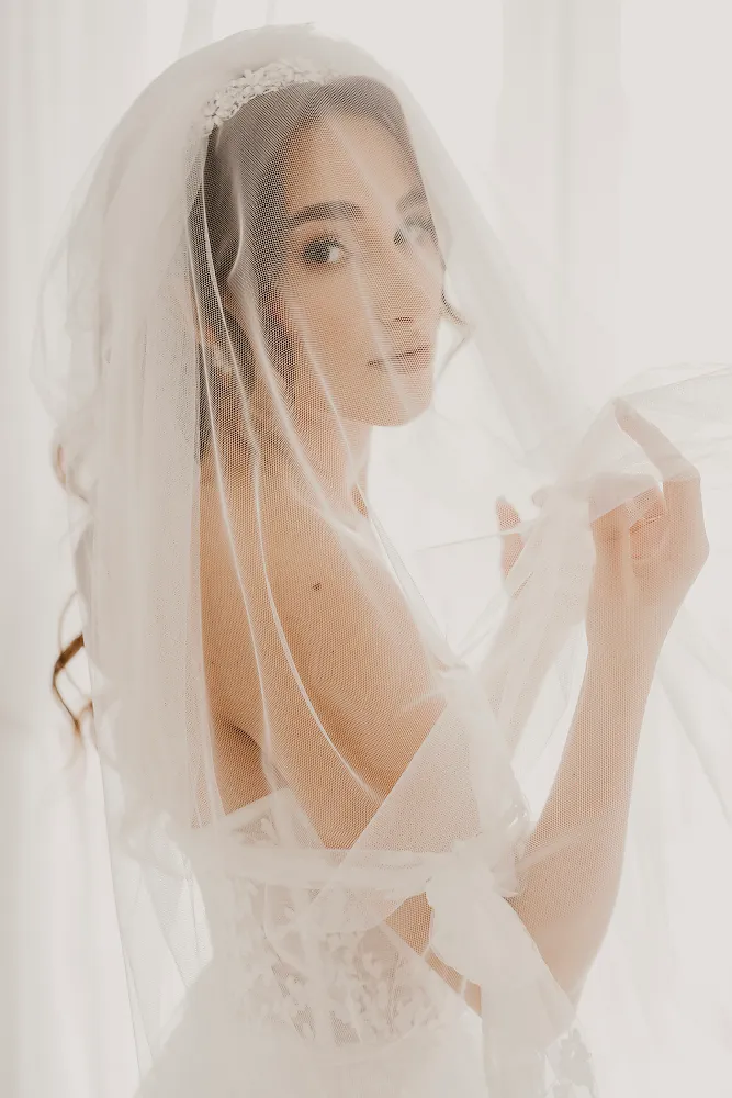 Panna młoda w welonie przy jasnym oknie Panna młoda w welonie przy jasnym oknie