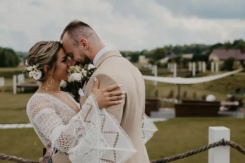 Para młoda przytulona po ceremonii ślubnej na zewnątrz