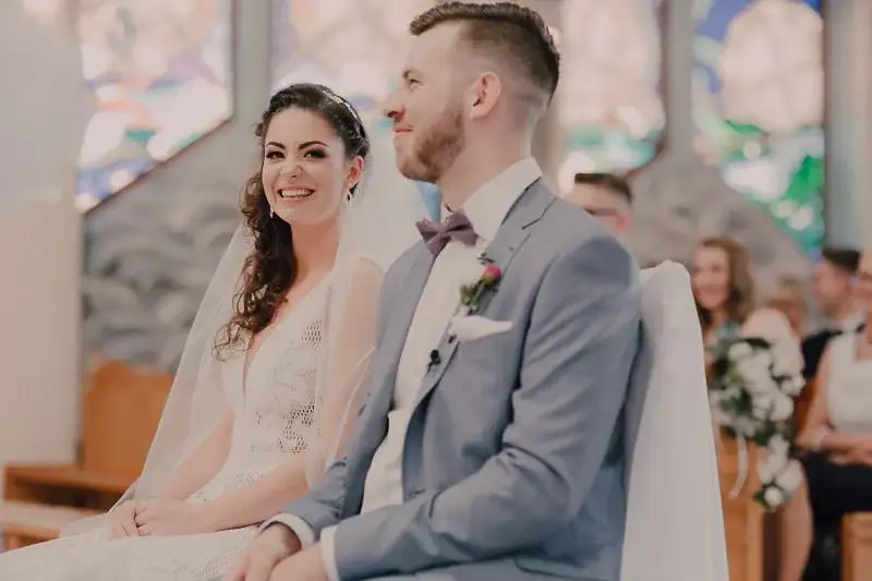 Uśmiechnięta para młoda podczas ceremonii w jasnym wnętrzu